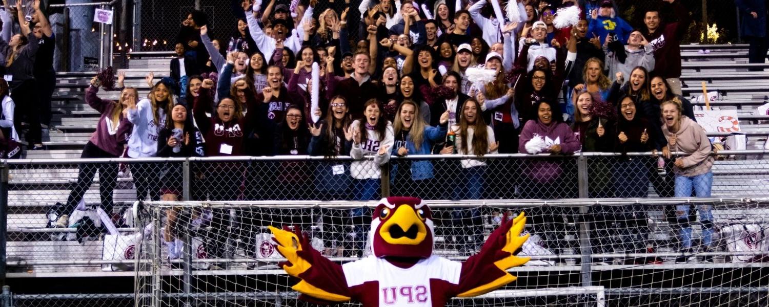SPU mascot, Talon, leads the crowd in cheers at a Falcon soccer game.