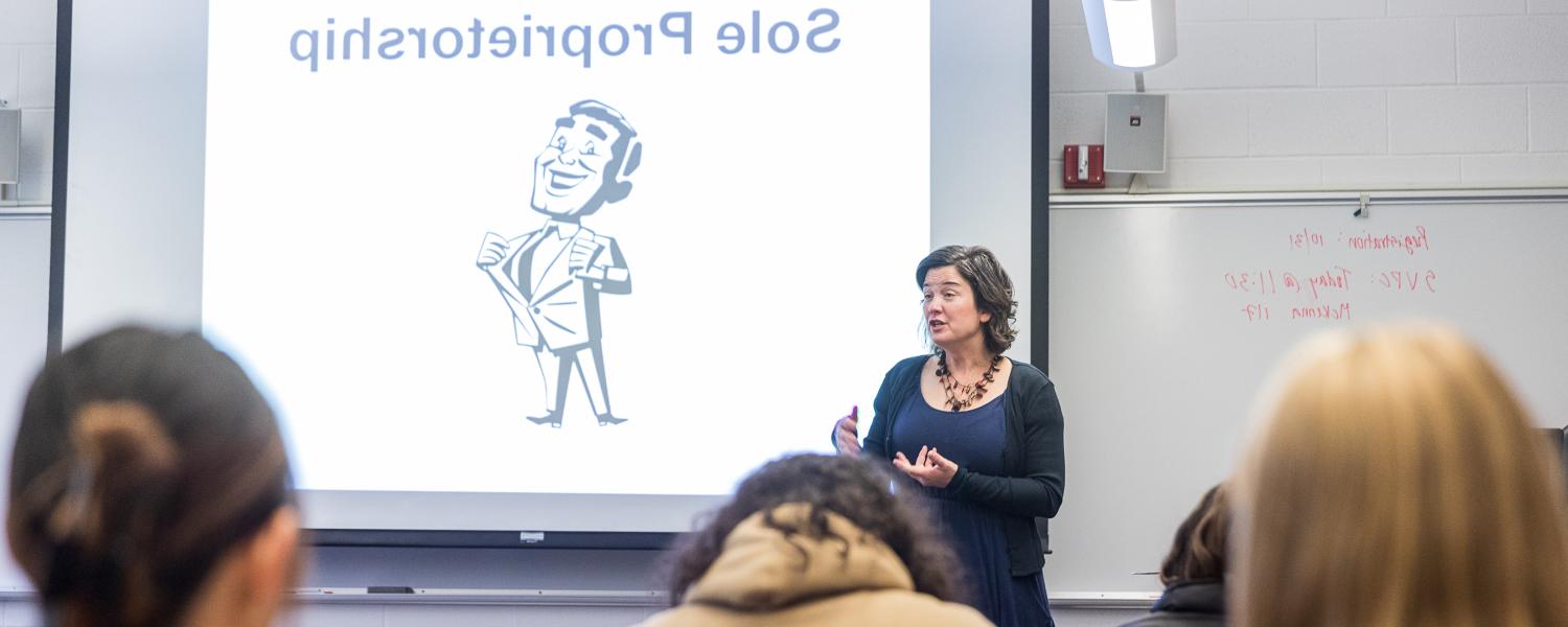 An SPU business professor speaks to her students from the front of a classroom at SPU.